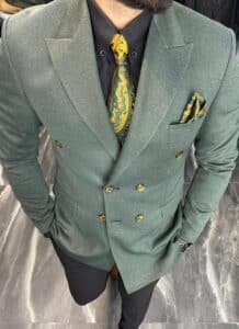 Fit check of a three-piece men's suit at shoulders, waistcoat, and trousers.